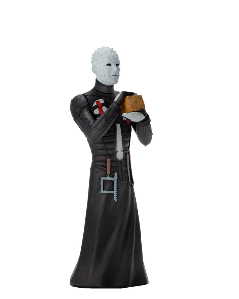 Pinhead NECA Tooney Terror action figure is standing in a black dress outfit with tools hanging from it, holding a brown box, with white lighting.