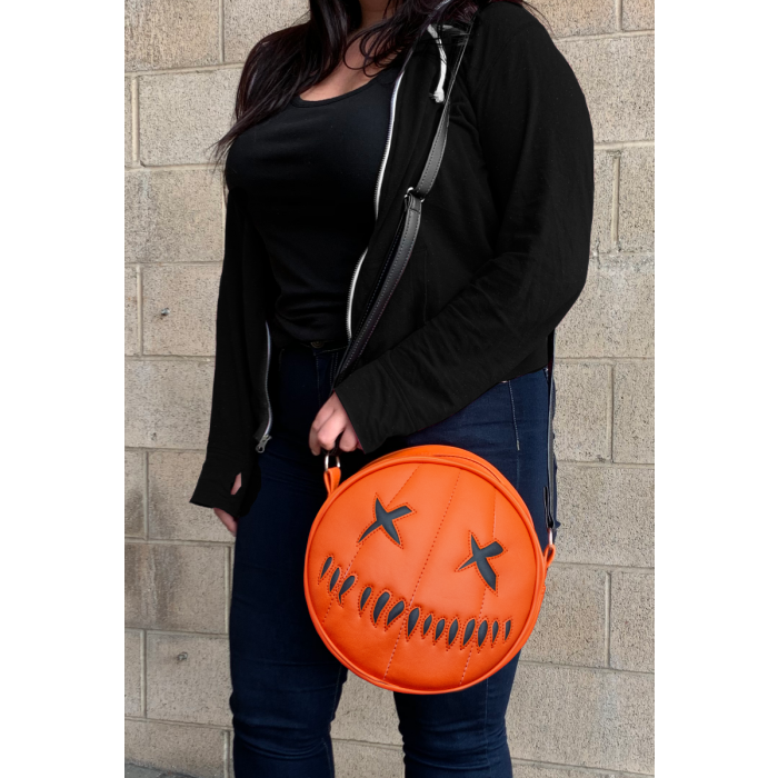 This is a Trick 'R Treat Sam pumpkin purse that is orange and has black eyes and mouth.