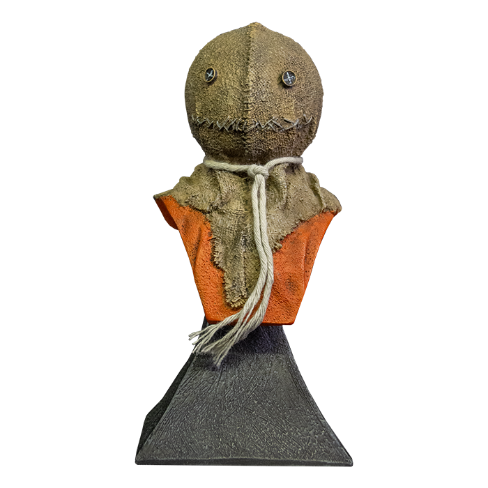 This is a Trick 'r Treat Sam mini bust and he is wearing a burlap mask with button eyes and an orange jumpsuit and he is on a grey stand.