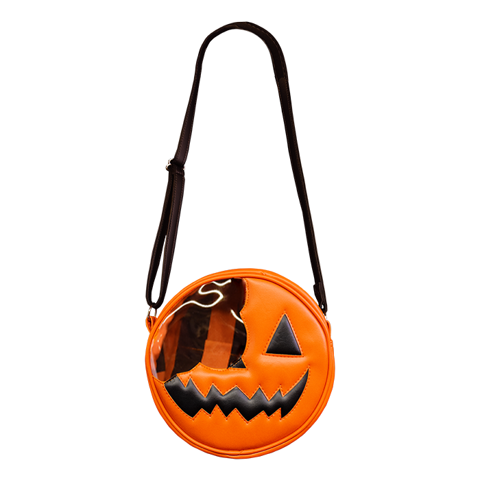 This is a Trick 'R Treat Sam bitten lollipop purse and it is orange, with a black eye and smile and has a black strap.