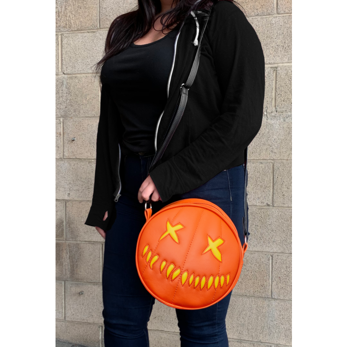 This is a Trick 'R Treat Sam pumpkin purse that is orange and has yellow eyes and mouth.