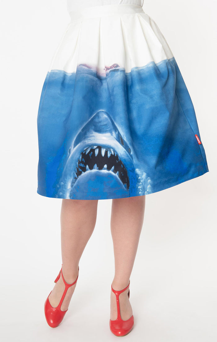 This is a Unique Vintage Jaws movie poster skirt and the skirt is white at the top, blue water on the bottom and a shark coming up to eat a swimmer.
