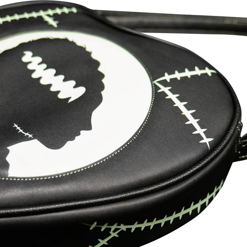 This is a Universal Monsters Bride of Frankenstein purse bag that is black with a strap and there are white and green stitches