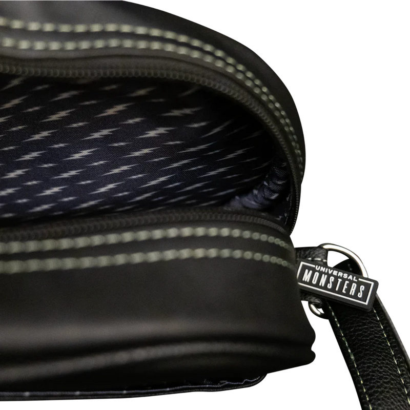 This is a Universal Monsters Bride of Frankenstein purse bag that is black with a strap, lightning bolts inside and a universal monsters tag