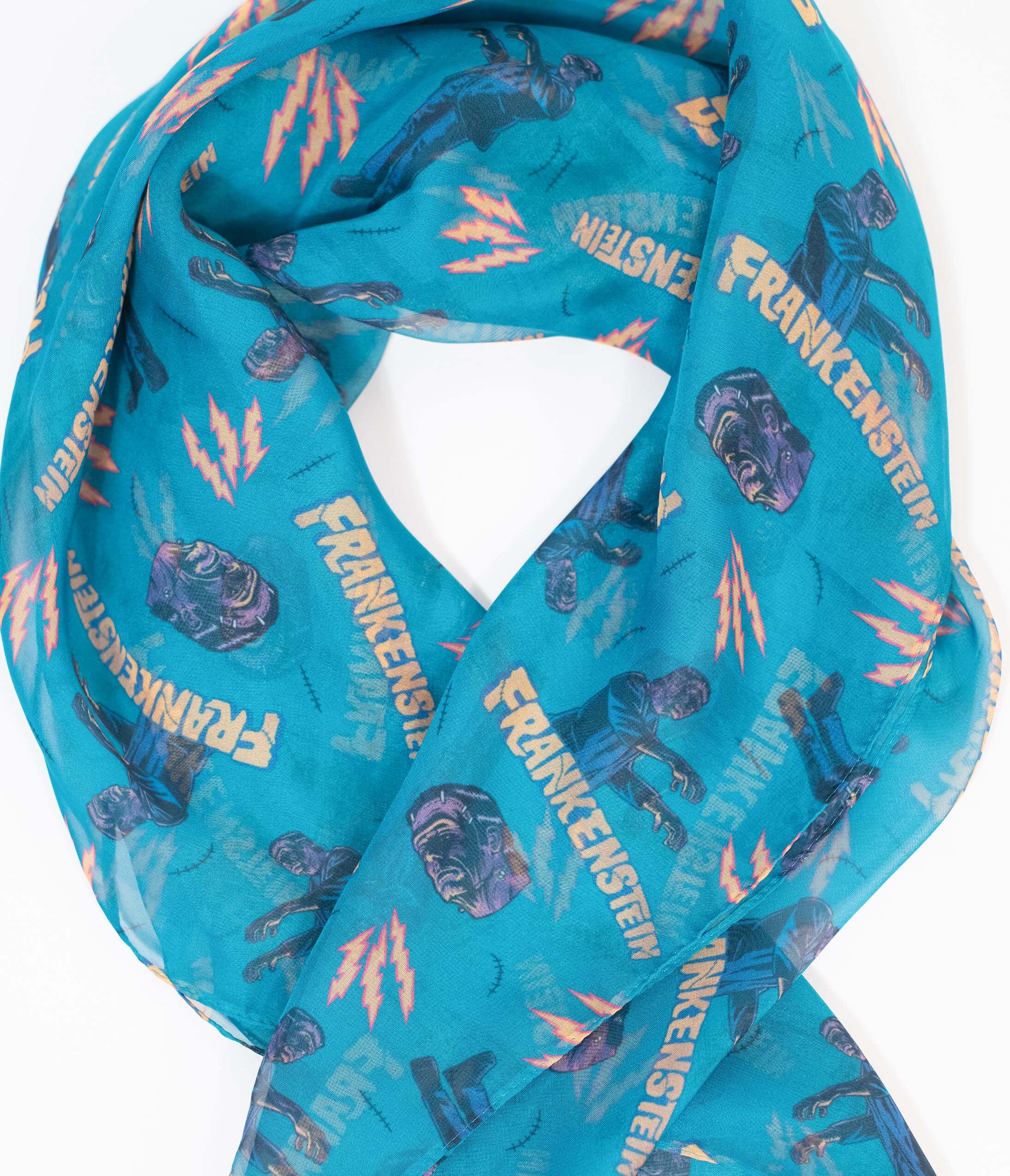 This is a Universal Monsters Frankenstein chiffon hair scarf that is teal and has yellow lightening bolts and heads on it.