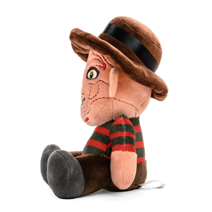 This is a Nightmare On Elm Street Freddy Krueger plush and he has a brown hat, red and green striped sweater, brown pants, grey feet, yellow eyes and a burnt face.