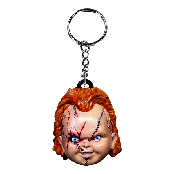 This is a Seed of Chucky Chucky keychain and he has a scarred face, orange hair, blue eyes and a silver chain and loop.
